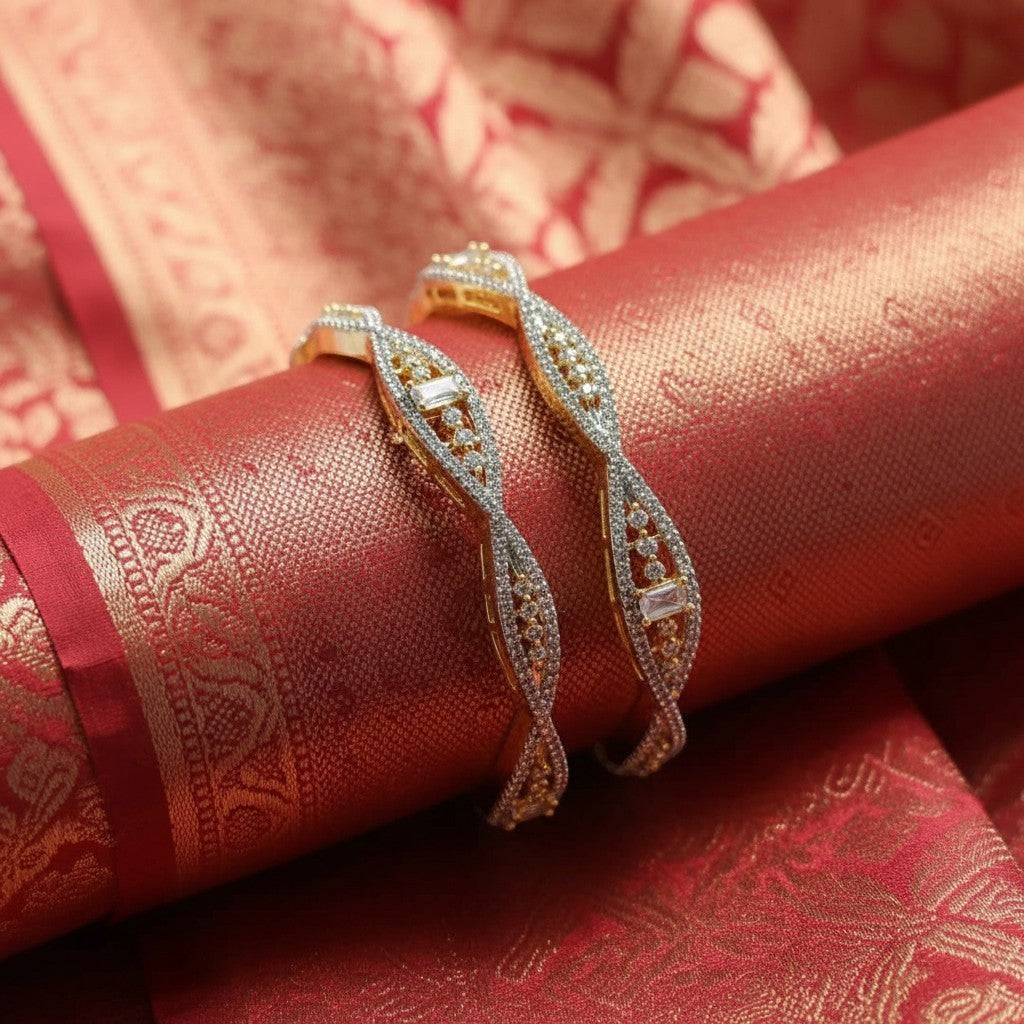 Shangri American Diamond bangles with golden polish and intricate stone detailing on a red silk fabric background.