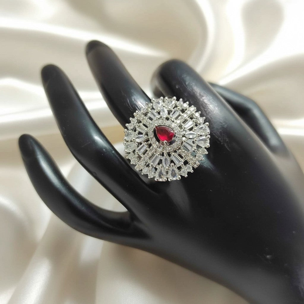 Shangri American Diamond floral halo ring with a red pear-cut center stone on a black display hand