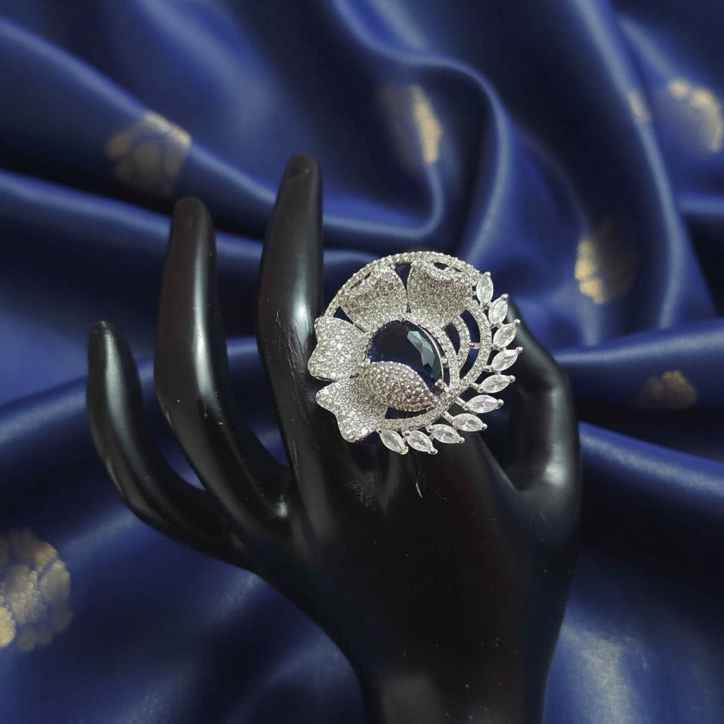 Shangri floral American Diamond adjustable ring featuring a deep blue centre stone on a black display hand