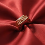 Shangri rose gold plated multi-band ring featuring sparkling Austrian stones on a red satin background.