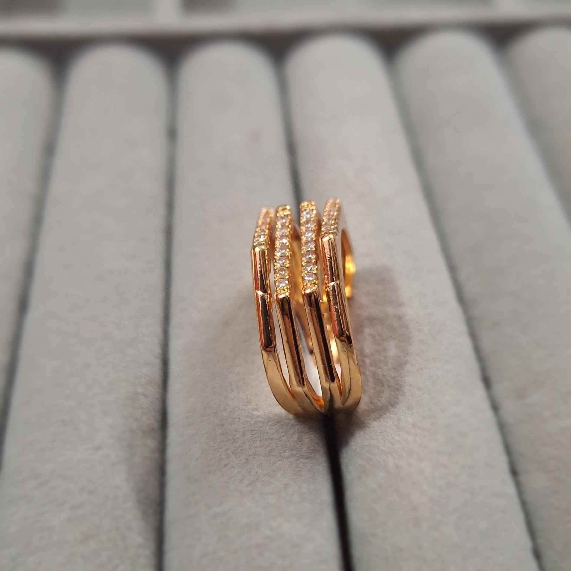 Shangri rose gold plated multi-band ring featuring sparkling Austrian stones on a grey velvet jewellery display.